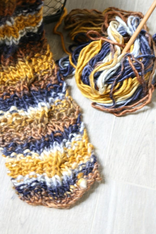 Knitting a cable knit scarf.