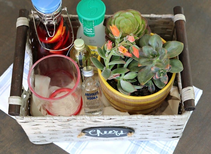 Homemade gift basket for a friend's birthday. Lemon Blueberry Simple Syrup, spirits, cocktail napkins, a summer glass, plus a succulent. 