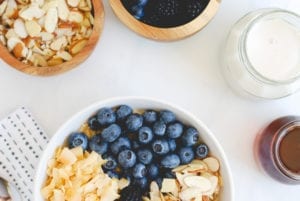 Quinoa Breakfast Bowl -- infused with sweet vanilla and topped with fresh berries, roasted coconut, slivered almonds and a drizzle of pure maple syrup! || Simply Happenstance